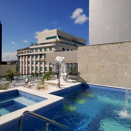 호텔 아틀란티코 비즈니스 센트로 리오데자네이루 외부 사진 The photo shows a rooftop area featuring a swimming pool and a spa. The pool is inviting with a clear blue water, and there appears to be a waterfall feature. Surrounding the pool are areas for relaxation, possibly with sun loungers. In the backgroun