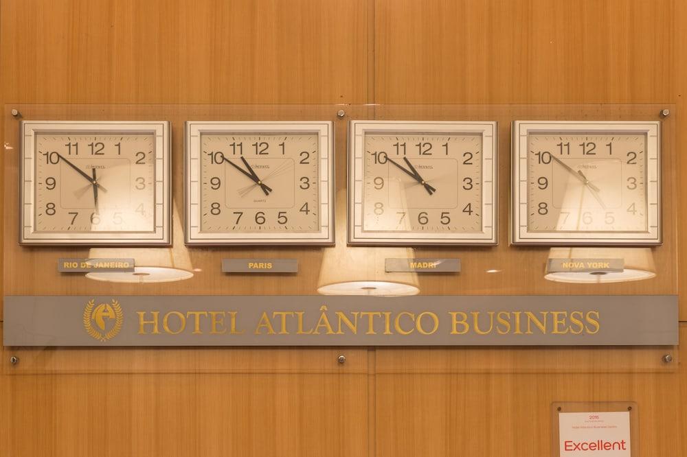 호텔 아틀란티코 비즈니스 센트로 리오데자네이루 외부 사진 The photo displays a wooden wall featuring three wall clocks. Each clock shows a different time, indicating that they are set to various time zones. Below the clocks, there is a sign that reads "HOTEL ATLÂNTICO BUSINESS." There are also two lamp fixt